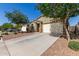 Single-story home with desert landscaping, mature shade trees, large driveway and an attached two-car garage at 36203 N Urika Dr, San Tan Valley, AZ 85140
