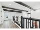 Bright hallway featuring exposed wood beam ceiling, wood floors, and decorative railing at 38953 N 57Th Pl, Cave Creek, AZ 85331
