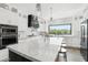 Bright, modern kitchen with white cabinets, marble counters, stainless steel appliances, and island seating at 38953 N 57Th Pl, Cave Creek, AZ 85331