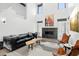 Stylish living room with fireplace, high ceilings, modern furniture, and abundant natural light at 38953 N 57Th Pl, Cave Creek, AZ 85331