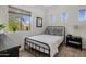 Neutral bedroom with a metal bed frame, roller shades, and plant accents at 3935 E Rough Rider Rd # 1252, Phoenix, AZ 85050