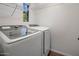 Bright laundry room featuring a modern, front-load washer and dryer and wire shelving at 3935 E Rough Rider Rd # 1252, Phoenix, AZ 85050