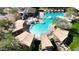 Aerial view of community pool featuring lounge chairs, umbrellas, and lush landscaping at 3935 E Rough Rider Rd # 1252, Phoenix, AZ 85050