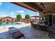 Backyard featuring a covered patio with furniture, pool, and beautiful landscaping at 42037 N Bradon Way, Phoenix, AZ 85086