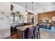 A stylish home bar featuring a granite countertop, tile accents, custom cabinetry, and pendant lighting at 42037 N Bradon Way, Phoenix, AZ 85086