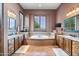 Open bathroom with dual vanities, custom cabinets, tile flooring, separate tub, and natural light at 42037 N Bradon Way, Phoenix, AZ 85086
