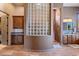 Inviting bathroom with a glass block privacy wall, custom cabinets, and tile flooring at 42037 N Bradon Way, Phoenix, AZ 85086