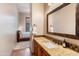 Bathroom featuring granite countertops and a decorative tile backsplash; bedroom visible in background at 42037 N Bradon Way, Phoenix, AZ 85086