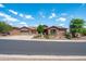 Attractive single-story home with a three-car garage, stone detailing, and mature desert landscaping at 42037 N Bradon Way, Phoenix, AZ 85086