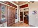 Charming foyer with a custom wood front door, travertine floors, and an office view at 42037 N Bradon Way, Phoenix, AZ 85086
