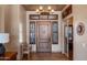 Elegant foyer featuring a custom wood front door, travertine floors, and a stylish chandelier at 42037 N Bradon Way, Phoenix, AZ 85086