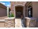 Welcoming front entry with a stone archway, iron gate, and decorative lanterns at 42037 N Bradon Way, Phoenix, AZ 85086