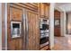 Close up of built-in stainless steel appliances, including oven and refrigerator, with custom wood finish at 42037 N Bradon Way, Phoenix, AZ 85086