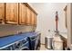 Laundry room with lots of cabinet space, modern washer and dryer, and utility sink at 42037 N Bradon Way, Phoenix, AZ 85086