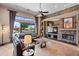 Spacious living room with a stone accent wall, fireplace, and large windows leading to outdoor patio at 42037 N Bradon Way, Phoenix, AZ 85086