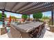 Outdoor kitchen featuring a built-in grill, bar seating, and a shaded pergola, creating a great space for al fresco dining at 42037 N Bradon Way, Phoenix, AZ 85086