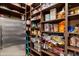Walk-in pantry includes stainless steel refrigerator and custom wood shelving, perfect for organization at 42037 N Bradon Way, Phoenix, AZ 85086
