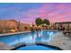 Resort-style backyard features a luxurious pool, cozy fireplace, lush greenery, and outdoor dining area at 42037 N Bradon Way, Phoenix, AZ 85086