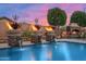 Scenic backyard with a beautiful pool featuring waterfalls and stone fire bowls under a colorful sky at 42037 N Bradon Way, Phoenix, AZ 85086