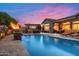 Serene backyard pool with a stone fire bowl, outdoor kitchen, covered patio, and ample seating at 42037 N Bradon Way, Phoenix, AZ 85086