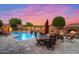 Beautiful backyard with a pool, fireplace, and outdoor seating area under a colorful sunset sky at 42037 N Bradon Way, Phoenix, AZ 85086