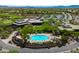 Aerial view of a community pool with lounge chairs and lush landscaping, next to a golf green and clubhouse at 42037 N Bradon Way, Phoenix, AZ 85086