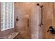 This tiled walk-in shower features a bench, glass block window and a hand-held shower fixture at 42037 N Bradon Way, Phoenix, AZ 85086