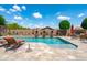 Lush backyard oasis featuring a sparkling pool with lounge chairs, and meticulously xeriscaped desert landscaping at 42037 N Bradon Way, Phoenix, AZ 85086