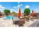 Relaxing pool area with a dining table, barbecue, fireplace, lounge chairs, and mature trees for a serene outdoor experience at 42037 N Bradon Way, Phoenix, AZ 85086