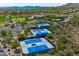 An aerial view of multiple blue community tennis courts surrounded by trees and desert landscaping at 42037 N Bradon Way, Phoenix, AZ 85086