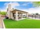 Spacious backyard featuring a covered patio, lush artificial grass, and a fenced pool area at 4292 E Terrace Ave, Gilbert, AZ 85234