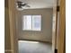 A cozy bedroom featuring neutral carpet, a window, and a ceiling fan with lighting at 43845 W Elizabeth Ave, Maricopa, AZ 85138