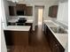 Kitchen with stainless steel appliances, an island, white counters, and dark wood cabinets at 43845 W Elizabeth Ave, Maricopa, AZ 85138
