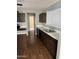 Kitchen with stainless steel appliances, an island, white counters, and dark wood cabinets at 43845 W Elizabeth Ave, Maricopa, AZ 85138