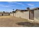Spacious backyard with textured walls and wooden gate, providing privacy and ample space at 4549 W Mclellan Rd, Glendale, AZ 85301