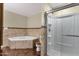 Bathroom featuring a soaking tub with marble surround and separate shower with glass enclosure at 4549 W Mclellan Rd, Glendale, AZ 85301
