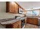 Practical kitchen featuring wood cabinets, a sleek cooktop, and plenty of counter space at 4549 W Mclellan Rd, Glendale, AZ 85301
