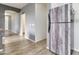 View showcasing wood-look flooring, leading into hallway and a uniquely wrapped refrigerator at 46185 W Dutchman Dr, Maricopa, AZ 85139