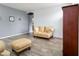 Bright living room with wood-look tile flooring, neutral walls, comfortable furniture and decor at 46185 W Dutchman Dr, Maricopa, AZ 85139