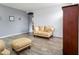 Bright living room with wood-look tile flooring, neutral walls, comfortable furniture and decor at 46185 W Dutchman Dr, Maricopa, AZ 85139