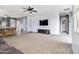 Expansive living room with plush carpeting, a modern TV console, and a relaxing atmosphere at 46185 W Dutchman Dr, Maricopa, AZ 85139