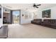 Spacious living room featuring carpet, neutral walls, natural light, and sliding glass door access to the backyard at 46185 W Dutchman Dr, Maricopa, AZ 85139