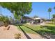 Backyard with covered patio, dining area, BBQ grill, and green lawn at 4711 S Los Feliz Dr, Tempe, AZ 85282