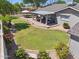 Large backyard featuring a covered patio, lush lawn, mature trees, and beautiful landscaping creating a serene oasis at 4711 S Los Feliz Dr, Tempe, AZ 85282