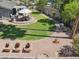 Spacious backyard with a paver patio, lush lawn, mature trees, and rock landscaping for outdoor enjoyment at 4711 S Los Feliz Dr, Tempe, AZ 85282