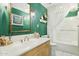 Bathroom with green walls, light-colored vanity with white marble countertop, and bathtub with shower at 4711 S Los Feliz Dr, Tempe, AZ 85282