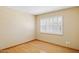 A simply staged bedroom has hardwood floors, plantation shutters, and light neutral walls at 4711 S Los Feliz Dr, Tempe, AZ 85282