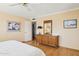 Spacious bedroom boasts hardwood floors, sunny yellow walls and a large dresser with decorative mirror at 4711 S Los Feliz Dr, Tempe, AZ 85282