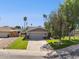 Inviting single-story home with a spacious driveway, lush lawn, and mature trees providing shade and curb appeal at 4711 S Los Feliz Dr, Tempe, AZ 85282