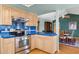 A bright kitchen features light wood cabinets, stainless steel appliances and blue tiled counter tops at 4711 S Los Feliz Dr, Tempe, AZ 85282